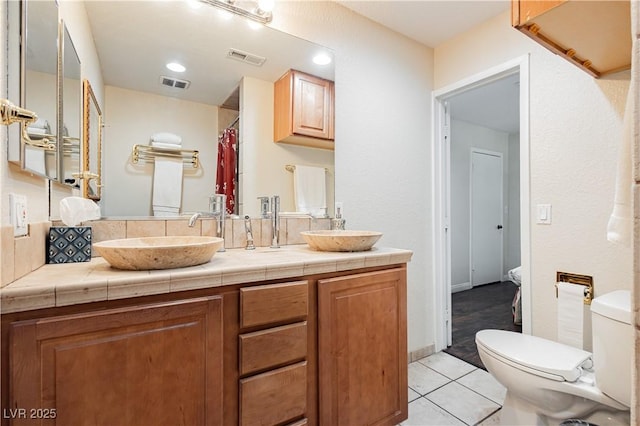 bathroom with vanity, tile patterned floors, and toilet