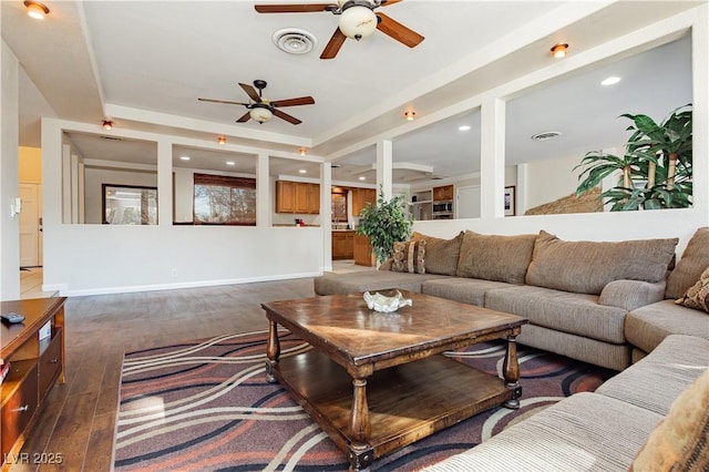 living room with ceiling fan, dark hardwood / wood-style flooring, and a tray ceiling