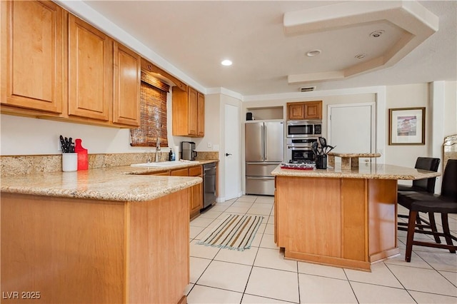 kitchen featuring sink, light tile patterned floors, a kitchen breakfast bar, stainless steel appliances, and light stone countertops