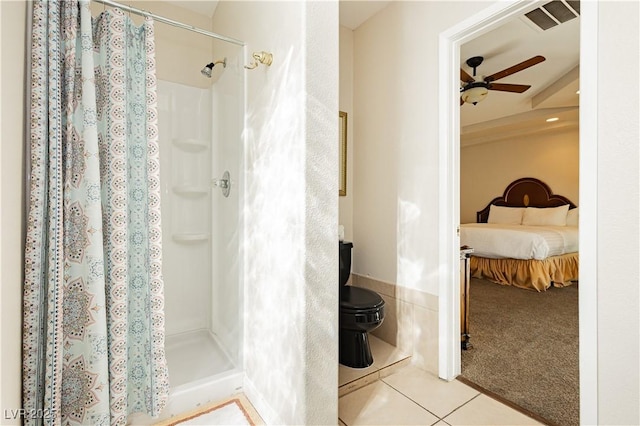 bathroom featuring ceiling fan, toilet, curtained shower, and tile patterned flooring