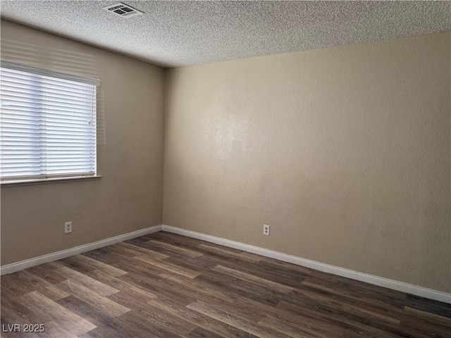 unfurnished room with a textured ceiling and dark hardwood / wood-style flooring