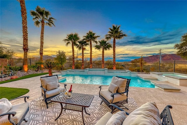 pool at dusk with an outdoor living space, an in ground hot tub, and a patio