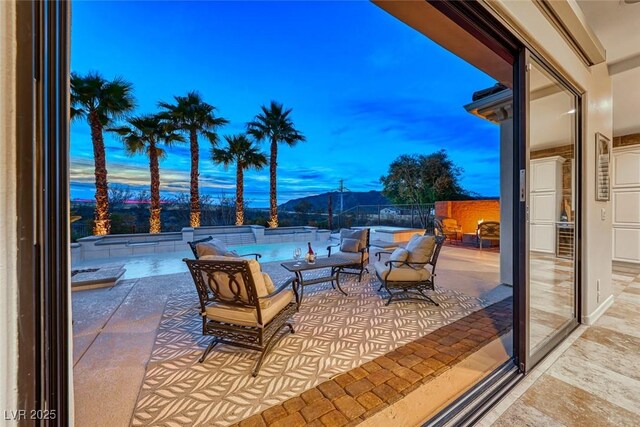 patio terrace at dusk with a fenced in pool