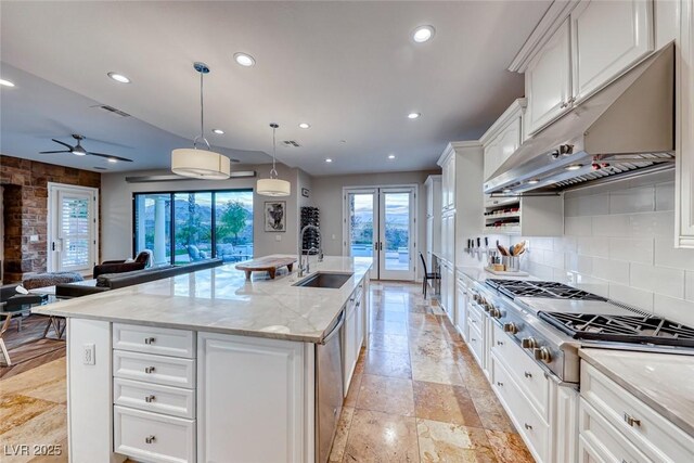 kitchen with white cabinetry, sink, an island with sink, and hanging light fixtures