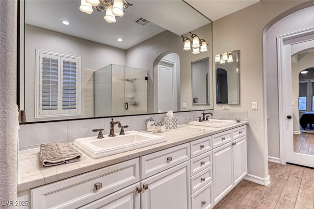 bathroom with vanity, hardwood / wood-style floors, a chandelier, and walk in shower