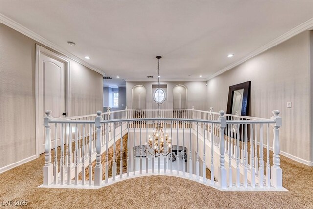 hallway featuring ornamental molding, carpet floors, and a notable chandelier