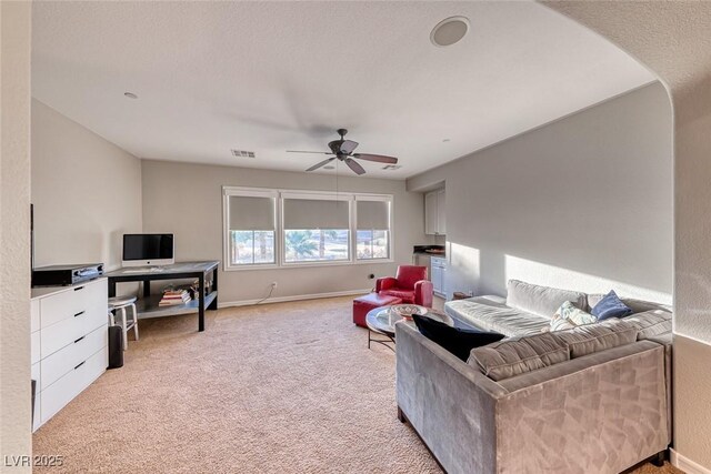 carpeted living room with ceiling fan