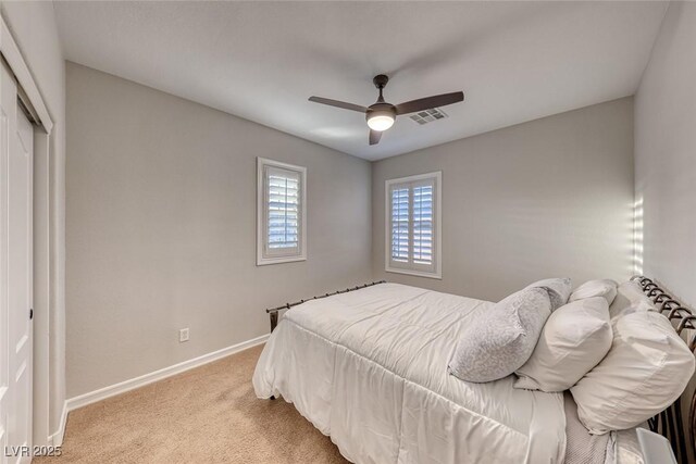 carpeted bedroom featuring ceiling fan and a closet