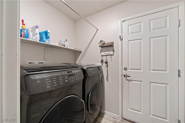 laundry area with separate washer and dryer and light hardwood / wood-style flooring