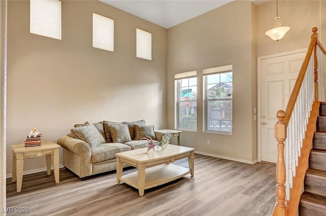 living room with a towering ceiling and wood-type flooring