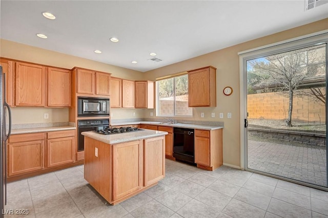 kitchen with light tile patterned flooring, black appliances, and a kitchen island