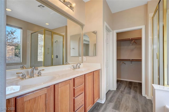 bathroom featuring vanity, a shower with shower door, and wood-type flooring