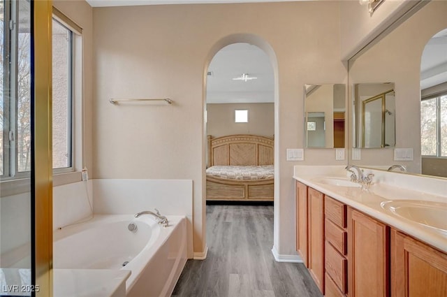 bathroom with hardwood / wood-style flooring, a bathing tub, and vanity