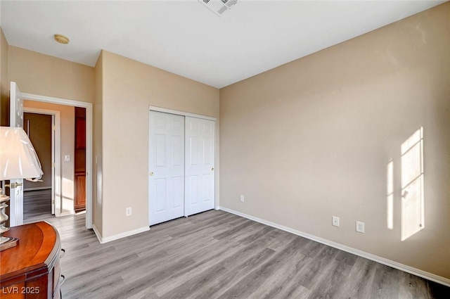 unfurnished bedroom with a closet and light hardwood / wood-style flooring