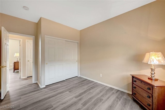 unfurnished bedroom with a closet and light hardwood / wood-style flooring