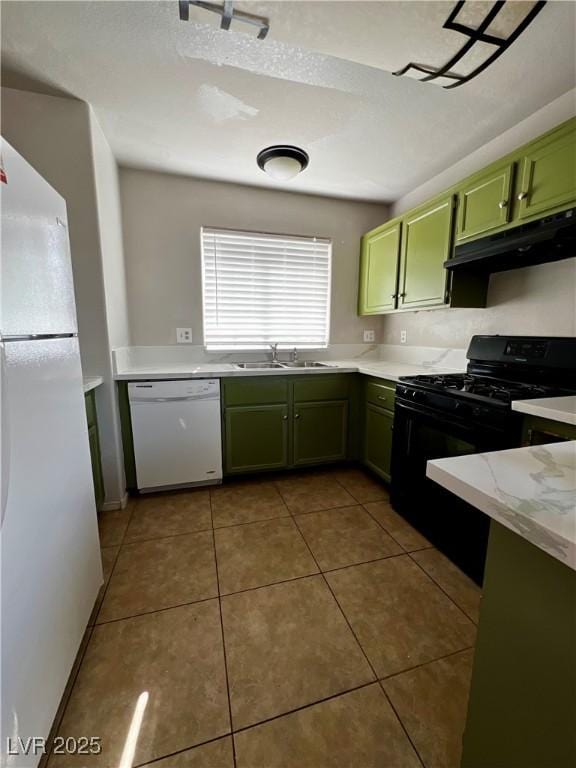 kitchen with white appliances, tile patterned flooring, sink, and green cabinetry