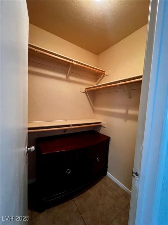 walk in closet featuring dark tile patterned floors