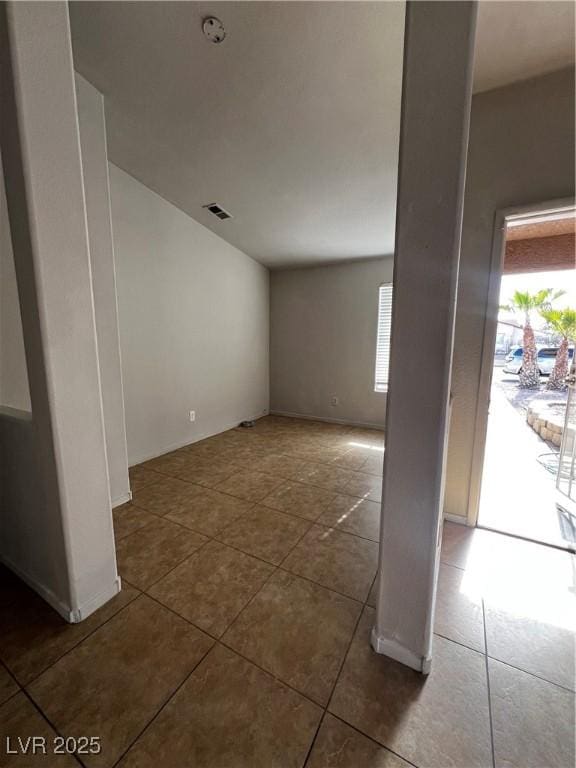 empty room featuring dark tile patterned floors and a wealth of natural light