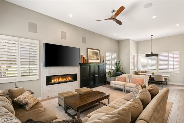 living room with ceiling fan and light hardwood / wood-style floors