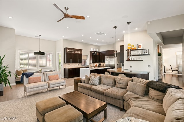 living room featuring ceiling fan and light hardwood / wood-style flooring