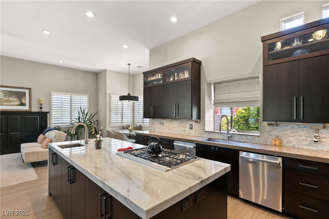 kitchen with stainless steel appliances, a center island, sink, and hanging light fixtures