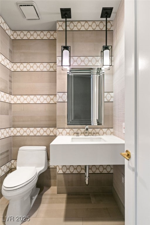 bathroom featuring tile walls, sink, tile patterned flooring, and toilet