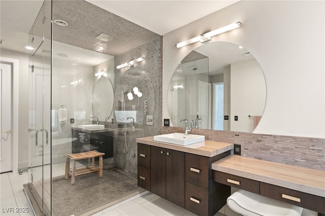 bathroom with walk in shower, tile patterned floors, vanity, and tasteful backsplash