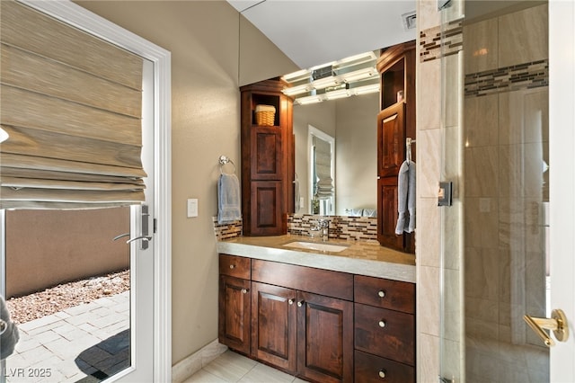 bathroom with vanity, backsplash, tile patterned floors, and a shower with door