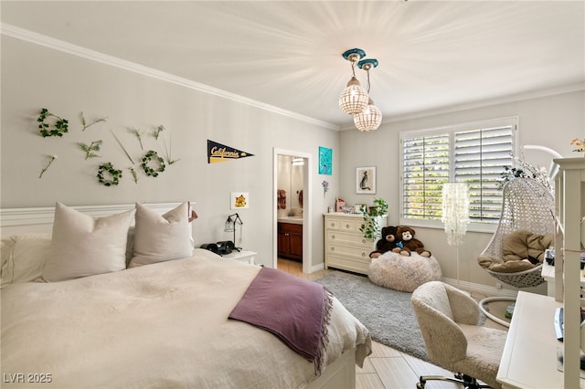 bedroom featuring ornamental molding, ensuite bathroom, and a notable chandelier