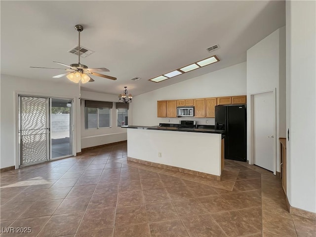 kitchen featuring dark countertops, visible vents, stainless steel microwave, and black refrigerator with ice dispenser