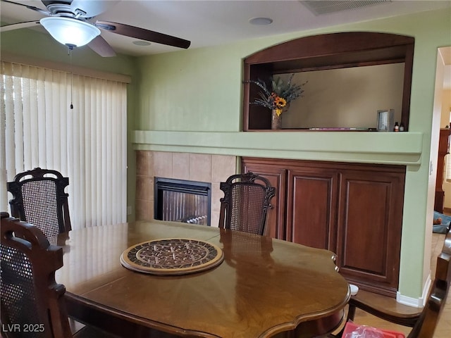 dining room featuring ceiling fan, a fireplace, and visible vents