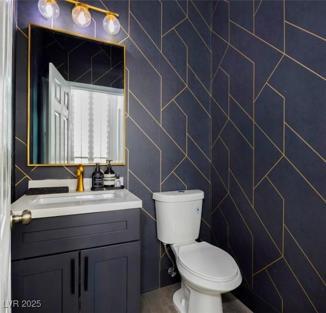 bathroom featuring vanity, toilet, and tile walls