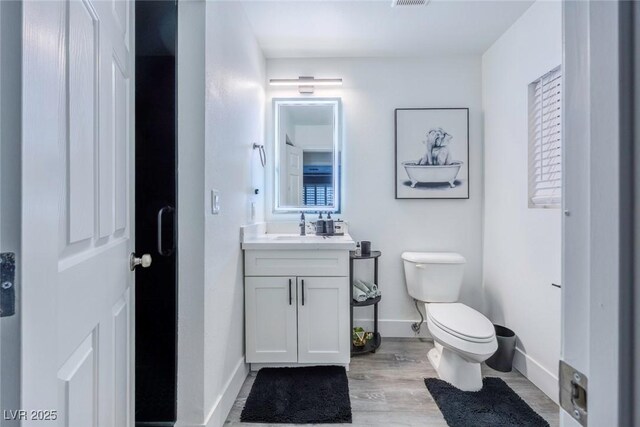 bathroom with vanity, hardwood / wood-style floors, and toilet