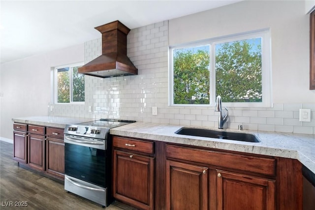 kitchen with sink, premium range hood, stainless steel range with electric stovetop, backsplash, and dark hardwood / wood-style flooring