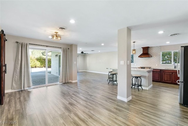 interior space featuring ceiling fan, sink, and light wood-type flooring