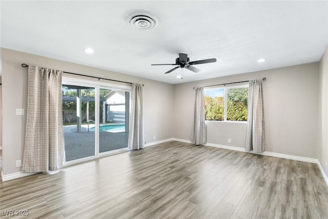 spare room featuring plenty of natural light, light hardwood / wood-style floors, and ceiling fan