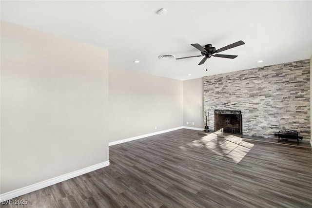 unfurnished living room featuring ceiling fan, dark hardwood / wood-style floors, and a tiled fireplace