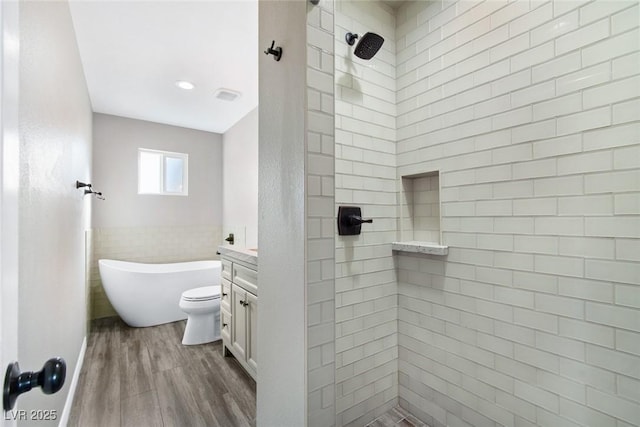 full bathroom with hardwood / wood-style flooring, tile walls, vanity, independent shower and bath, and toilet