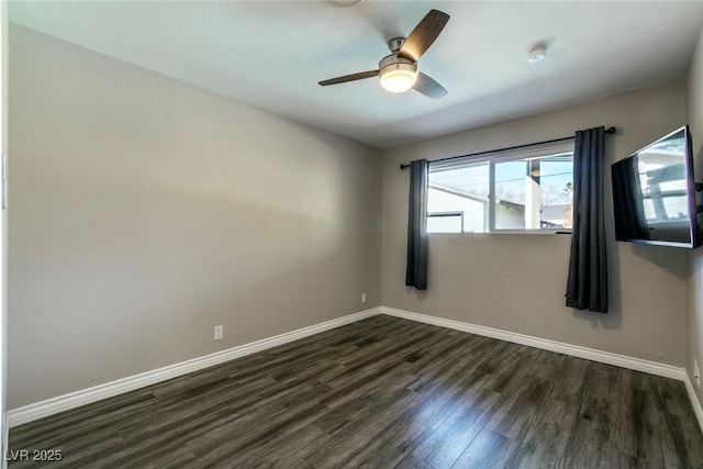 spare room with dark wood-type flooring and ceiling fan