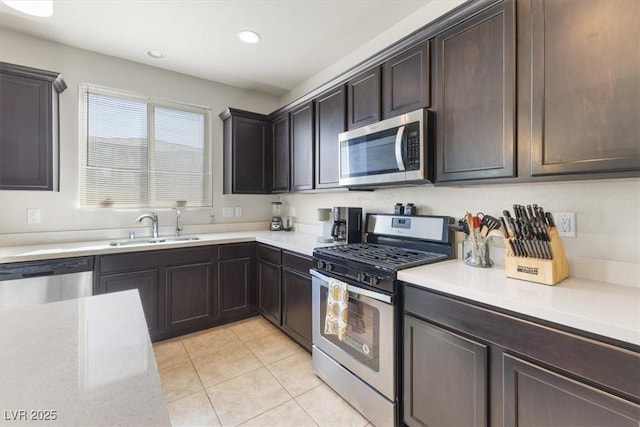 kitchen with light tile patterned flooring, appliances with stainless steel finishes, sink, and dark brown cabinetry