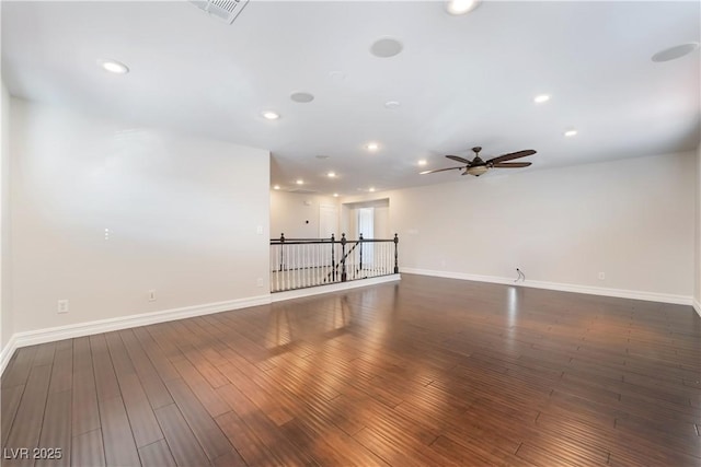 empty room with ceiling fan and dark hardwood / wood-style flooring