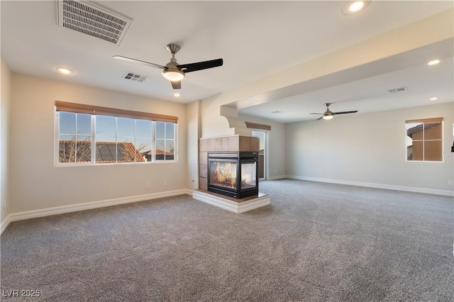 unfurnished living room with ceiling fan, a multi sided fireplace, and carpet flooring