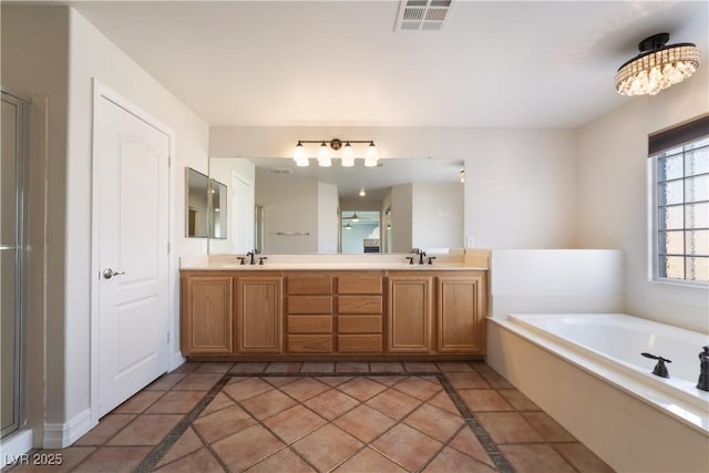 bathroom featuring vanity, a tub, and tile patterned floors