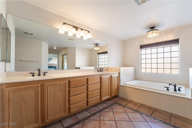 bathroom featuring vanity, tile patterned floors, and a tub to relax in