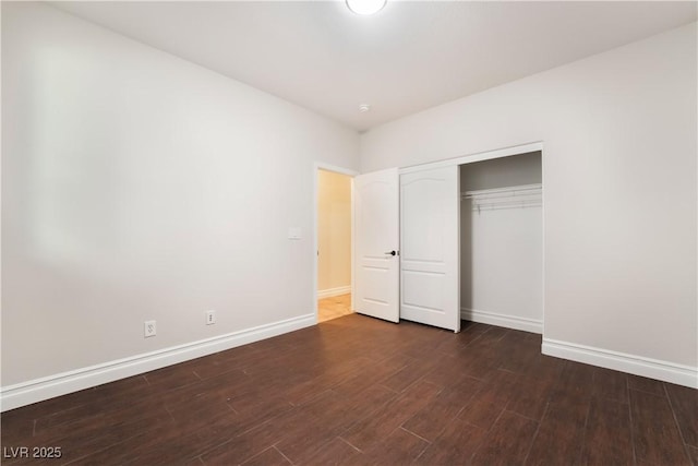 unfurnished bedroom with dark hardwood / wood-style floors and a closet