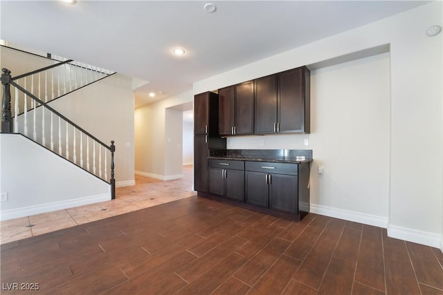 kitchen with dark brown cabinetry and dark hardwood / wood-style floors