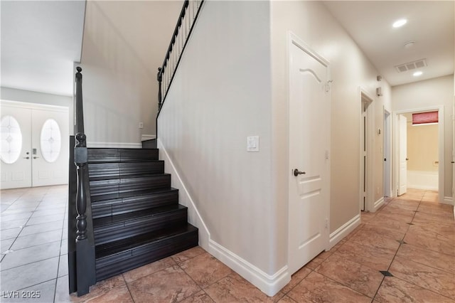 stairway featuring french doors and tile patterned floors