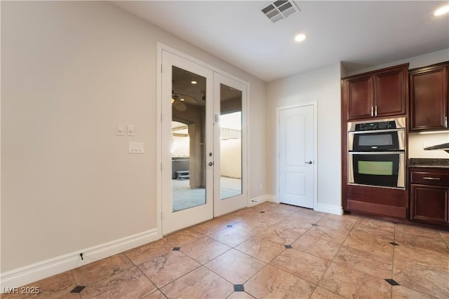 kitchen with double oven, dark brown cabinets, and french doors