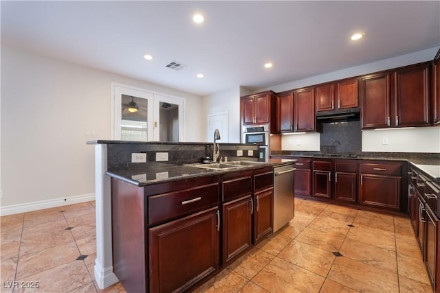 kitchen featuring light tile patterned flooring, appliances with stainless steel finishes, sink, and dark stone counters