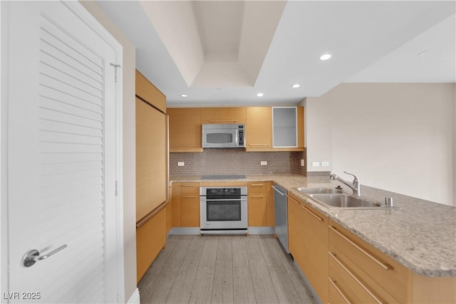 kitchen featuring sink, appliances with stainless steel finishes, tasteful backsplash, kitchen peninsula, and a raised ceiling